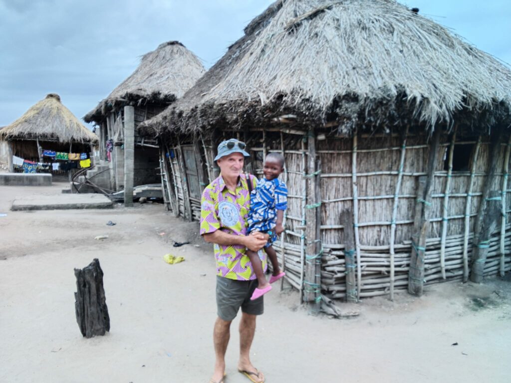 Alain Raffour avec Estelle devant les maisons d'Ahomey